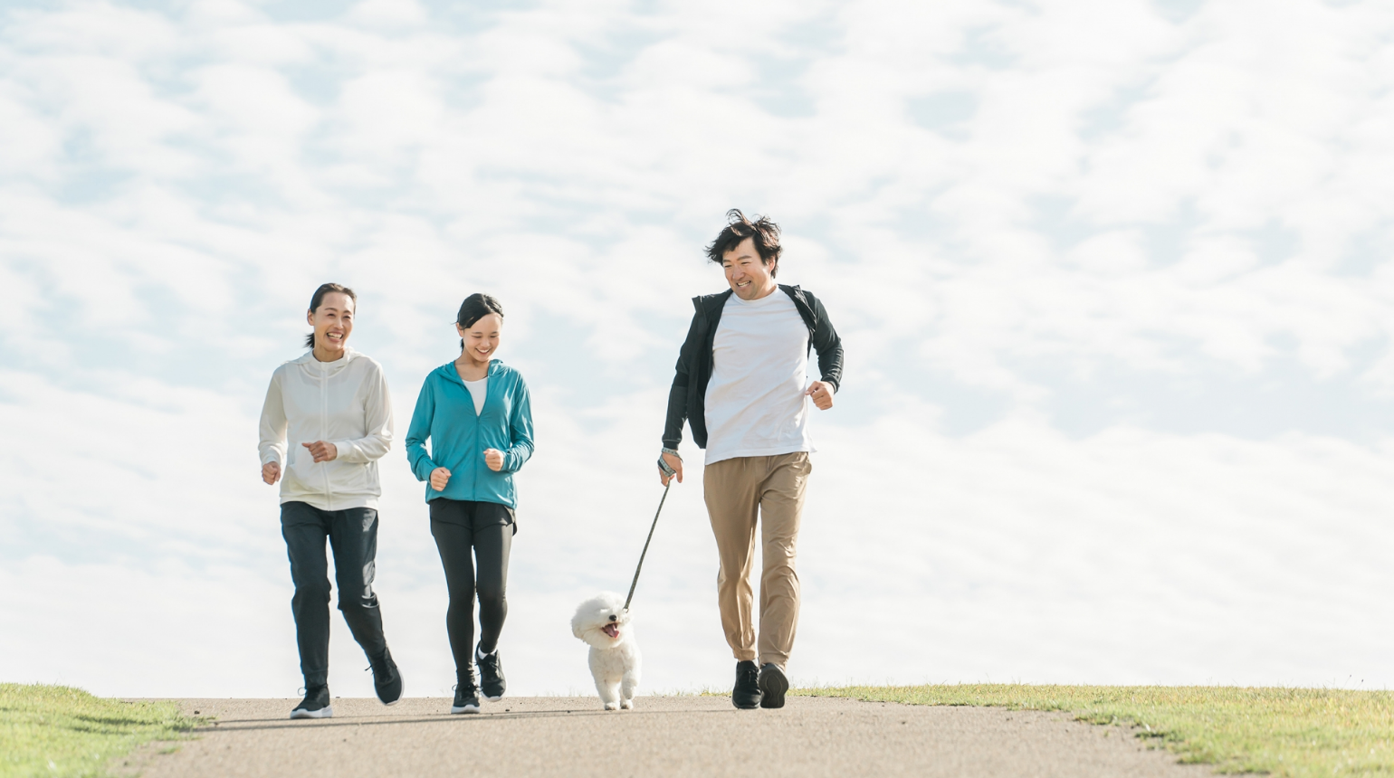 父と母と中学生の娘が犬の散歩をしている